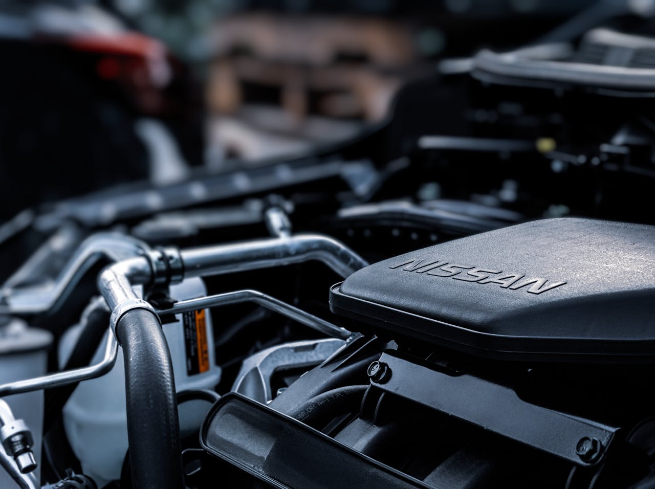 Detailed view of a car engine compartment with visible Nissan branding.